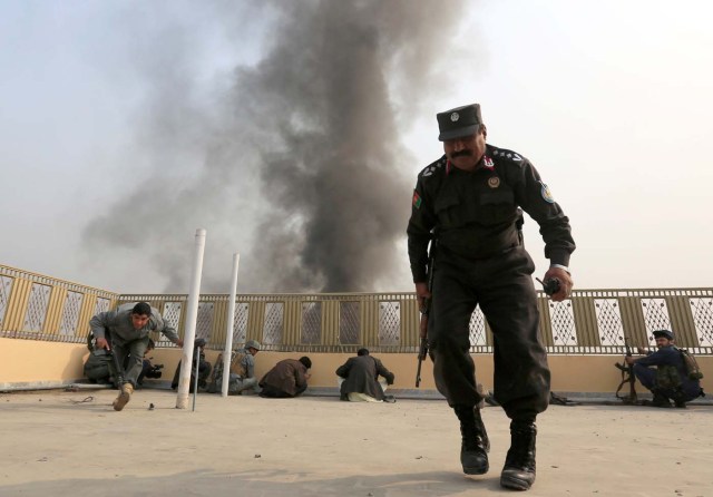 Afghan police officers take position during a blast and gun fire in Jalalabad, Afghanistan January 24, 2018.REUTERS/Parwiz