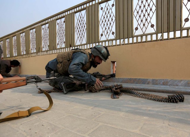 An Afghan police officer takes position during a blast and gun fire in Jalalabad, Afghanistan January 24, 2018.REUTERS/Parwiz