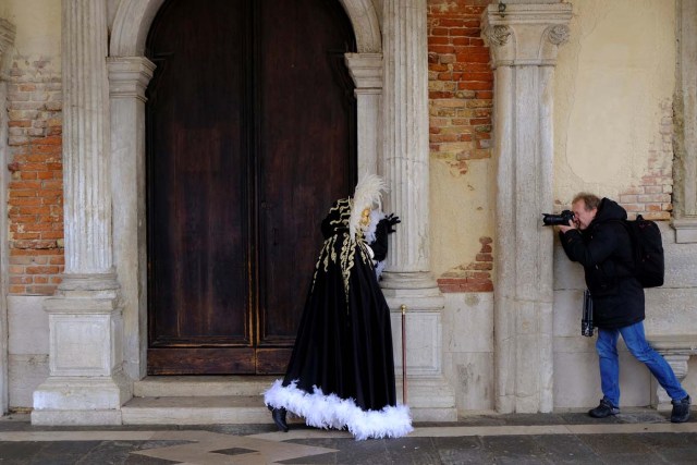 A masked reveller poses for a photographer during the Carnival in Venice, Italy January 28, 2018. REUTERS/Manuel Silvestri