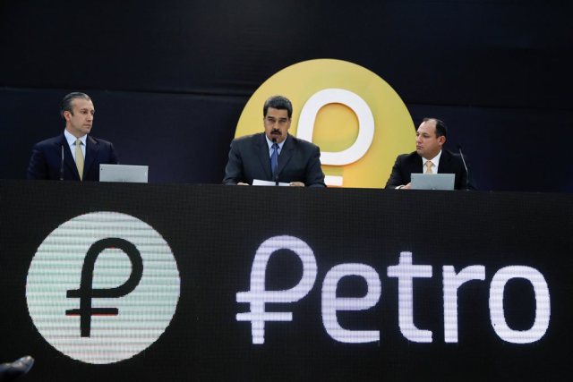 Venezuela's President Nicolas Maduro (C) speaks during the event launching the new Venezuelan cryptocurrency "Petro", next to Venezuela's Vice President Tareck El Aissami (L) and the Minister for University Education, Science and Technology Hugbel Roa, in Caracas, Venezuela February 20, 2018. REUTERS/Marco Bello