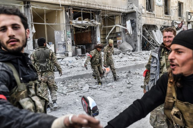  sirios respaldados por Turquía se reúnen en la ciudad de Afrin, en el norte de Siria, el 18 de marzo de 2018. Las fuerzas turcas y sus aliados rebeldes controlaban la ciudad de Afrin, de mayoría kurda, en el noroeste de Siria, informaron periodistas de la AFP. / AFP PHOTO / Bulent Kilic