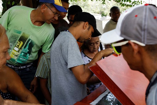Mourners look at the coffin of Javier Rivas, one of the inmates who died during a riot and fire in the cells of the General Command of the Carabobo Police, during his funeral in Valencia, Venezuela March 29, 2018. REUTERS/Carlos Garcia Rawlins