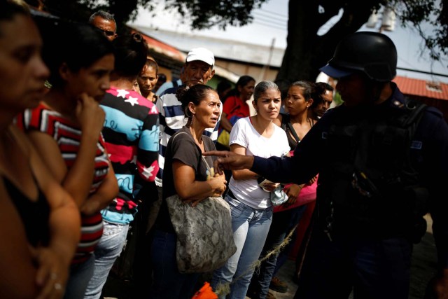 Los familiares de los presos hablan con un oficial de policía mientras esperan información luego de un motín y un incendio en las celdas del Comando General de la Policía de Carabobo en Valencia, Venezuela el 29 de marzo de 2018. REUTERS / Carlos Garcia Rawlins