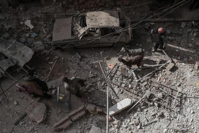 Varias personas caminan por un área destrozada tras un bombardeo en Duma (Siria) hoy, 19 de marzo de 2018. Según medios de comunicación, al menos nueve personas han muerto en el bombardeo que supuestamente fue llevado a cabo por las fuerzas leales al gobierno de Bachar Al Asad. EFE/ Mohammed Badra