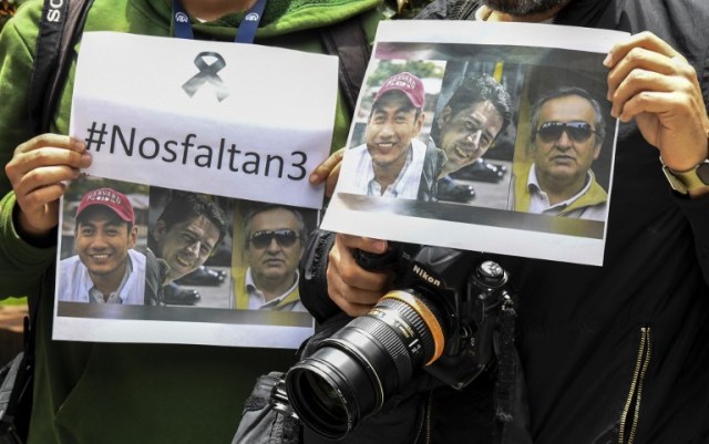 Colombian journalists gather in front of the Ecuadorean embassy in Bogota to protest against the murder of Ecuadorean journalist Javier Ortega, photographer Paul Rivas and their driver Efrain Segarra, on April 16 2018. The three members of an Ecuadoran journalist team who were kidnapped and killed in captivity after being abducted by a Colombian rebel group were following a story on violence that ended up costing their lives.  / AFP PHOTO / Luis ACOSTA