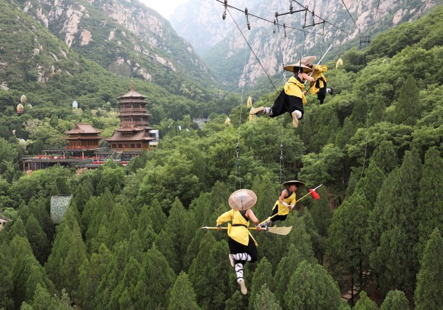 Shaolin martial arts students perform Kung Fu suspended on wires in a rehearsal for a live-action night show in Zhengzhou, Henan province, China April 28, 2018. Picture taken April 28, 2018. REUTERS/Stringer ATTENTION EDITORS - THIS IMAGE WAS PROVIDED BY A THIRD PARTY. CHINA OUT. NO COMMERCIAL OR EDITORIAL SALES IN CHINA.     TPX IMAGES OF THE DAY