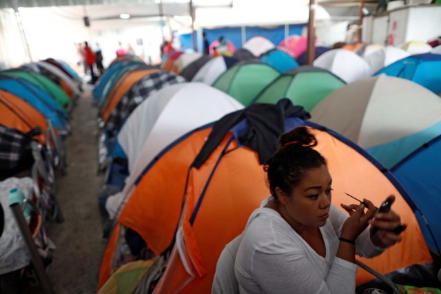 A woman, and a member of a caravan of migrants from Central America, puts on make-up at a shelter before a gathering in a park prior to preparations for an asylum request in the U.S., in Tijuana, Mexico April 29, 2018. REUTERS/Edgard Garrido