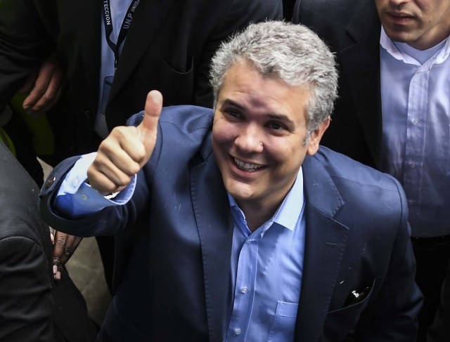 Colombian presidential candidate Ivan Duque, for the Democratic Centre party, gives his thumb up to supporters aftre voting at a polling station in Bogota during the first round of the presidential election in Colombia on May 27, 2018. Voters went to the polls Sunday to choose a new president of Colombia in a divisive election that is likely to weigh heavily on the future of the government's fragile peace deal with the former rebel movement FARC. / AFP PHOTO / Luis ACOSTA