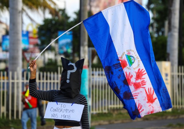 Un manifestante enmascarado sostiene una bandera nacional en apoyo de los adolescentes que murieron en recientes protestas contra el gobierno del presidente de Nicaragua, Daniel Ortega, en Managua, Nicaragua, el 1 de junio de 2018. REUTERS / Oswaldo Rivas