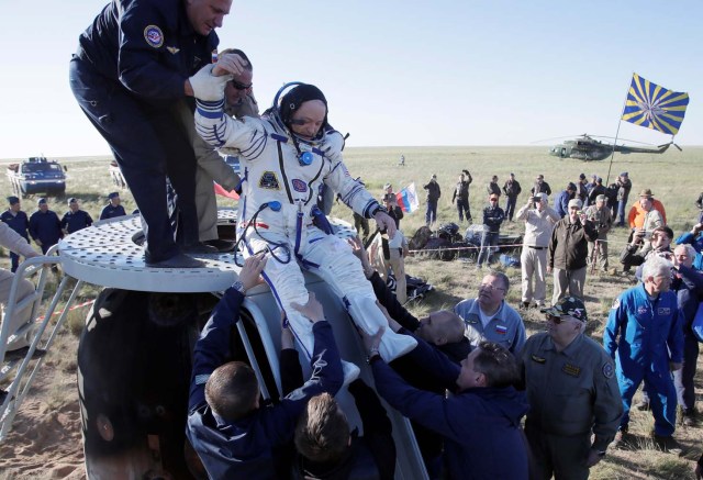 El personal de tierra ayuda a Scott Tingle de los EE. UU. A salir de la cápsula espacial Soyuz MS-07 poco después de aterrizar en un área remota a las afueras de la ciudad de Dzhezkazgan (Zhezkazgan), Kazajistán el 3 de junio de 2018. Dmitri Lovetsky / Pool vía REUTERS